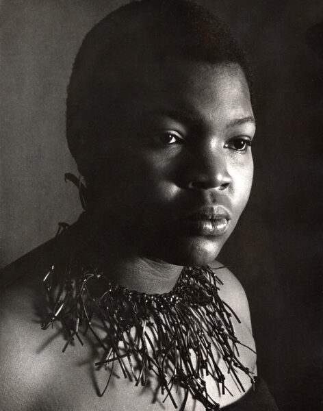 Sandy wearing her earrings and leather neckpiece. Her love of metal and leather designing is established. An Ed Sherman photo.