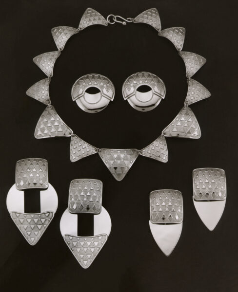 A silver ensemble: collar, earrings and pendants shown together.
