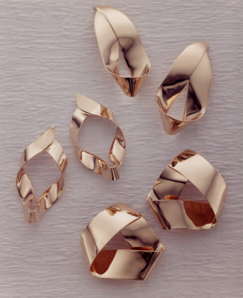 Faceted earrings with folded planes in warm metal.