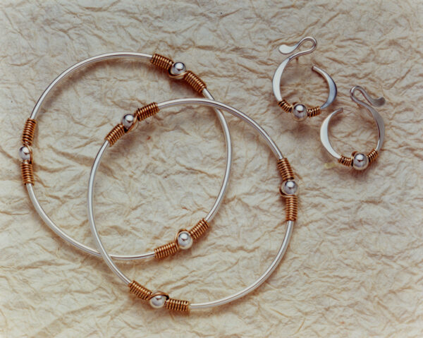 GRAND BASSAM Collection bangles and hoops, silver wrapped with copper detail.