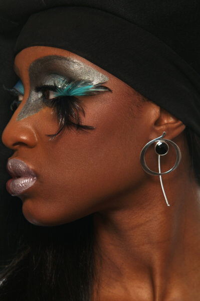 Model is wearing EARTH Earrings. A hand-forged circular comet with a breezy mobile at the back of the ear. A Wayne Summerlin photo.